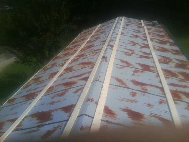 Rusted metal roof panels with new wood purlins before replacement — Storm Damage Roof Repair in Massapequa by Roofing Brothers