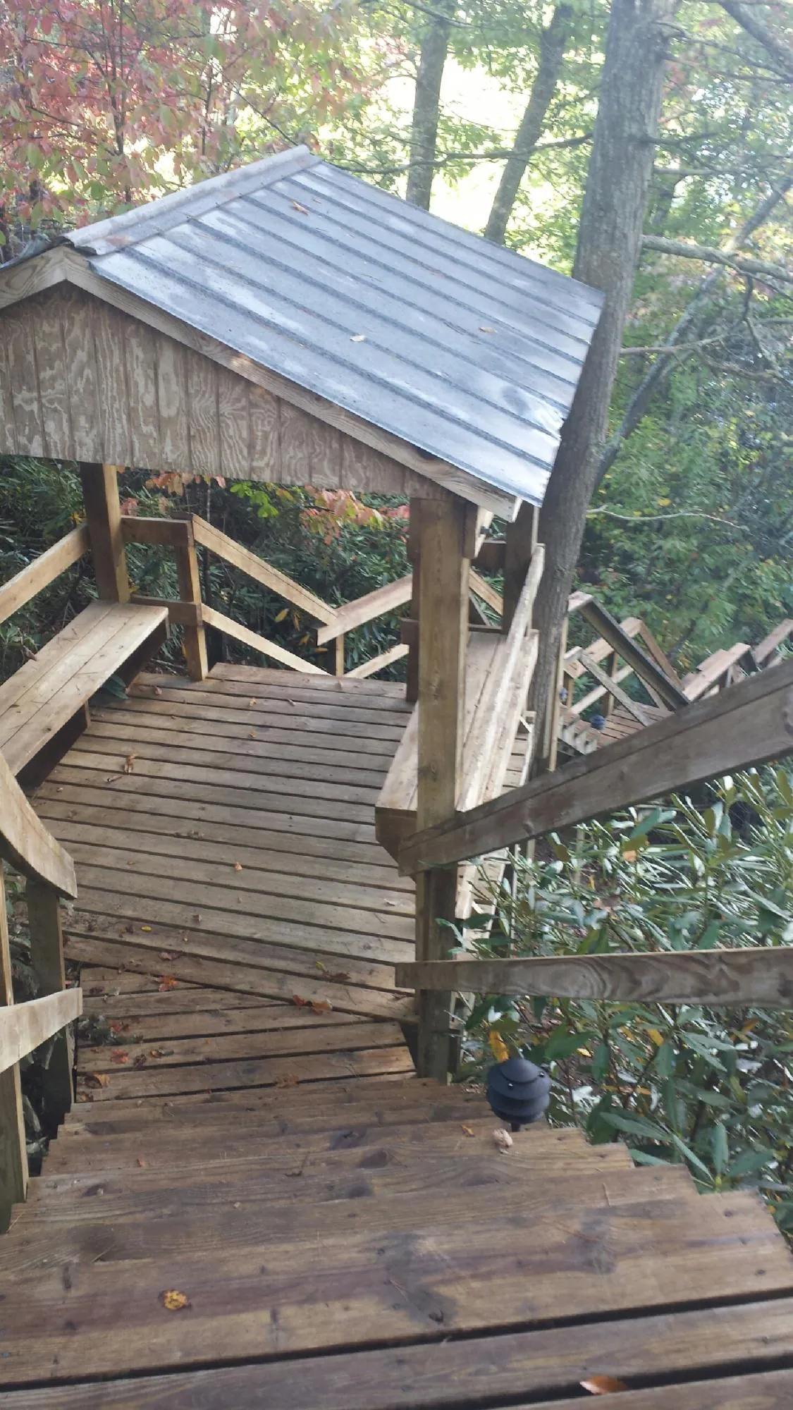 Metal roofed shelter over wooden steps on a wooded walkway — Skylight Repair & Installation work by our crew in Massapequa