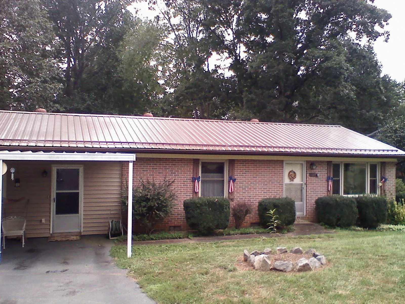 Bronze metal roof and carport on a brick ranch home — Roof Repair work by our crew in Massapequa